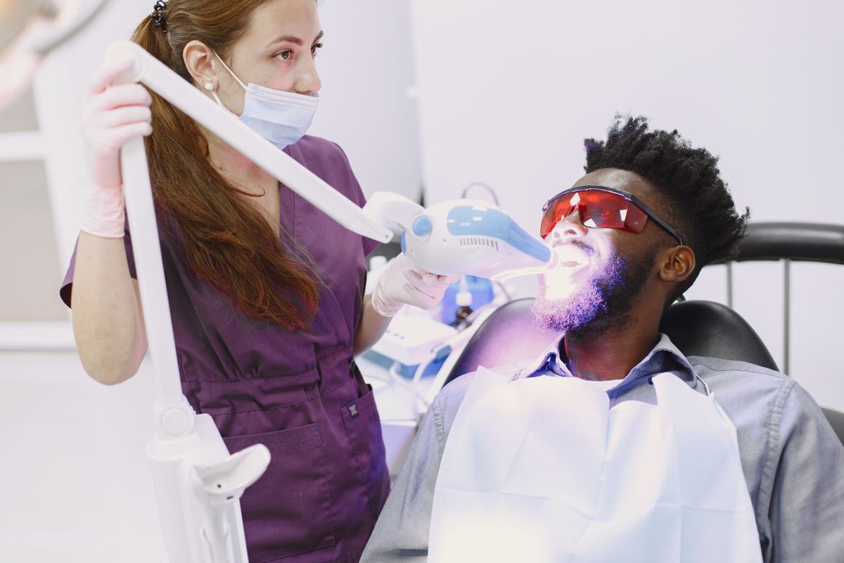 Patient receiving a professional teeth whitening treatment with specialised equipment